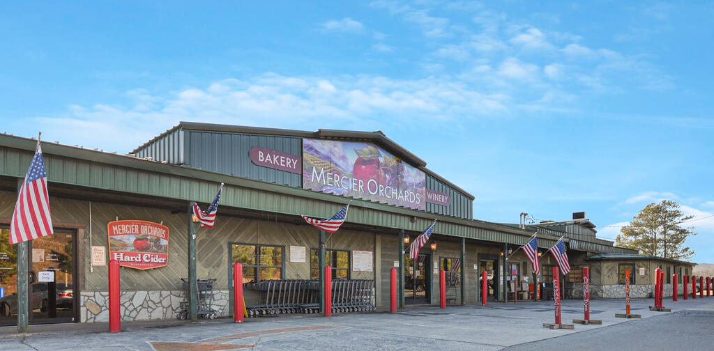 Mercier Orchards storefront with bakery and winery signs, shopping carts, and American flags.