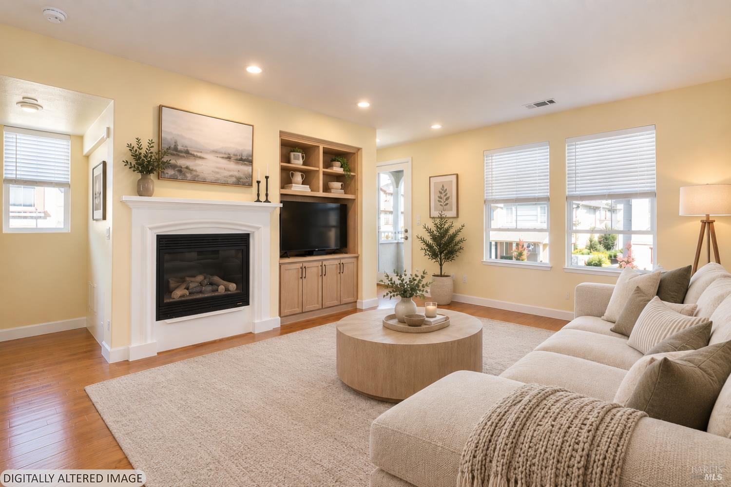 Staged living room with a white fireplace, built-in shelving, and a large beige sectional sofa.