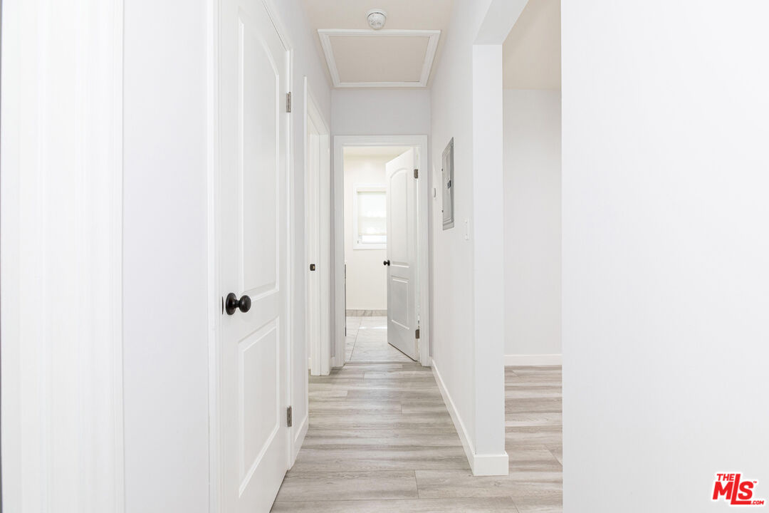 Bright hallway with white paneled doors and light gray wood-look flooring.