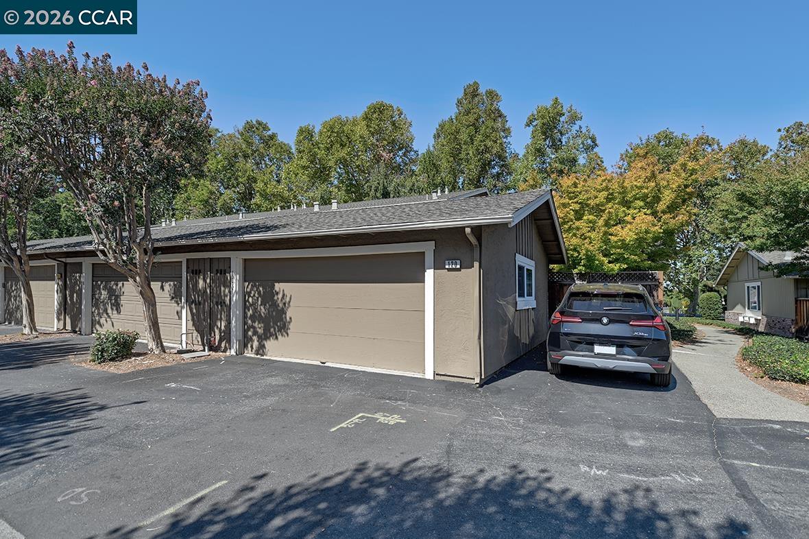 Single-story home with a broad garage and a car parked beside the driveway.