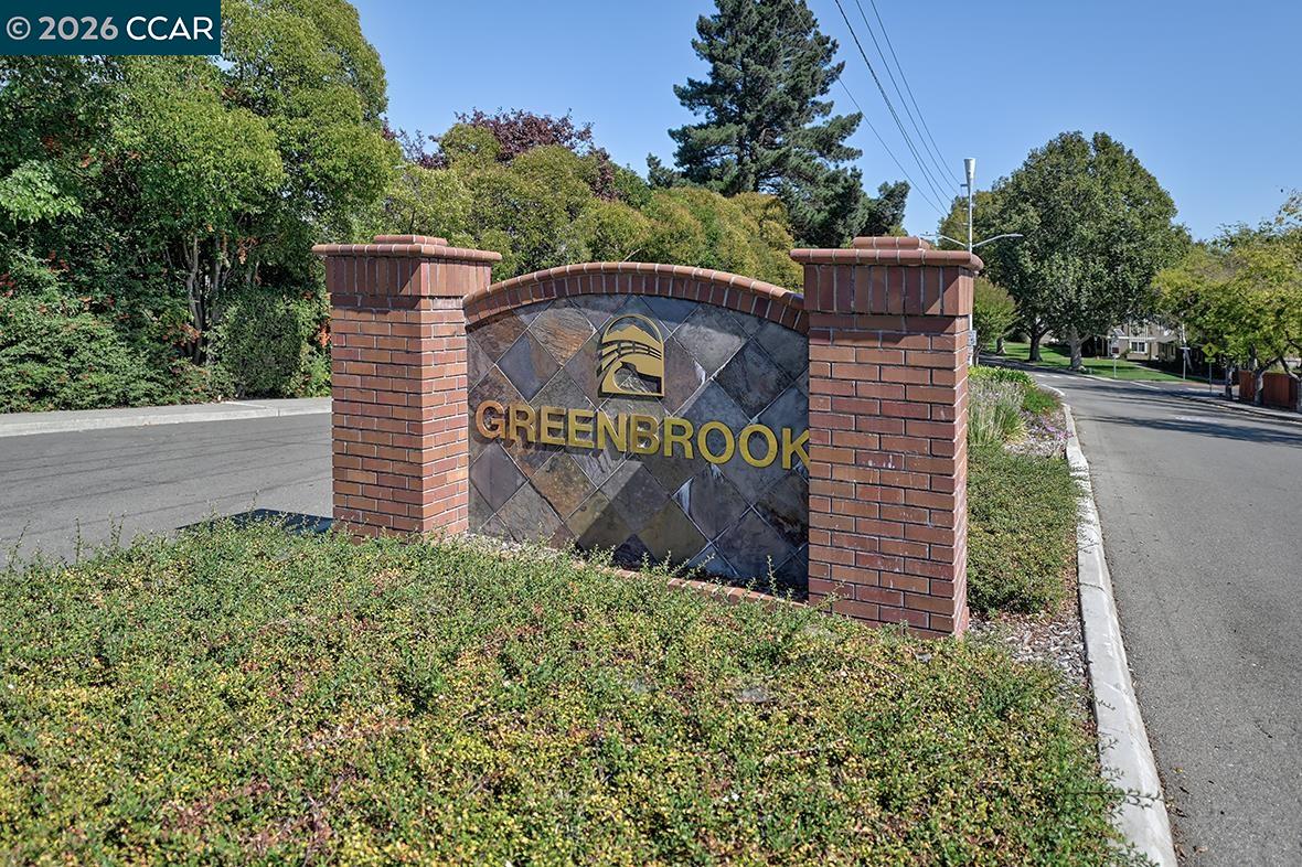 Greenbrook neighborhood entrance sign beside a landscaped street.