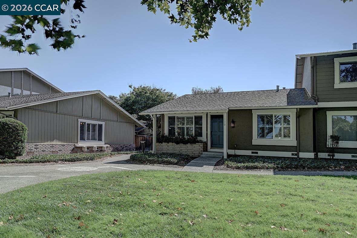 Home exterior with a blue front door, covered entry, and lawn.