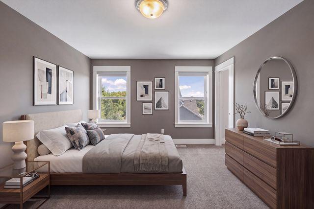 Staged bedroom with a low upholstered bed, two windows, and a long wood dresser.