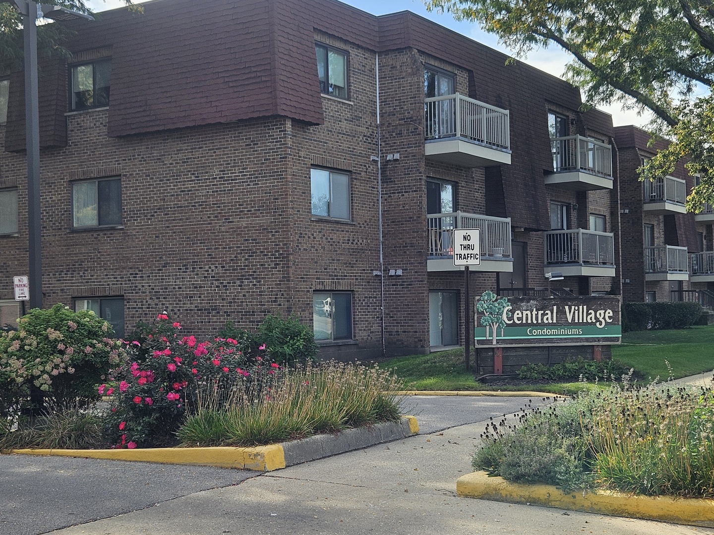 Central Village condominiums, a brick building with balconies and landscaped flower beds.