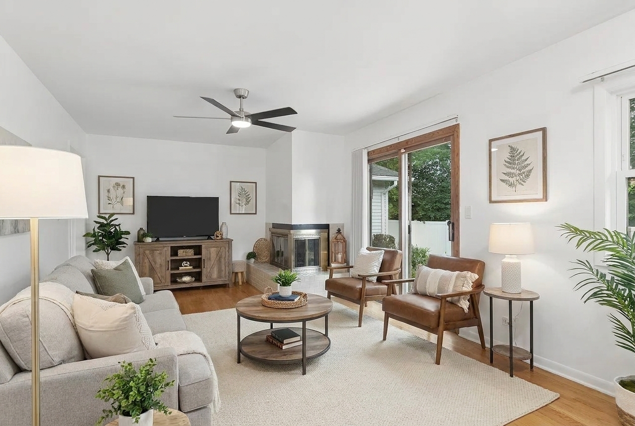 Living room with a fireplace, sliding glass doors, and neutral furnishings.
