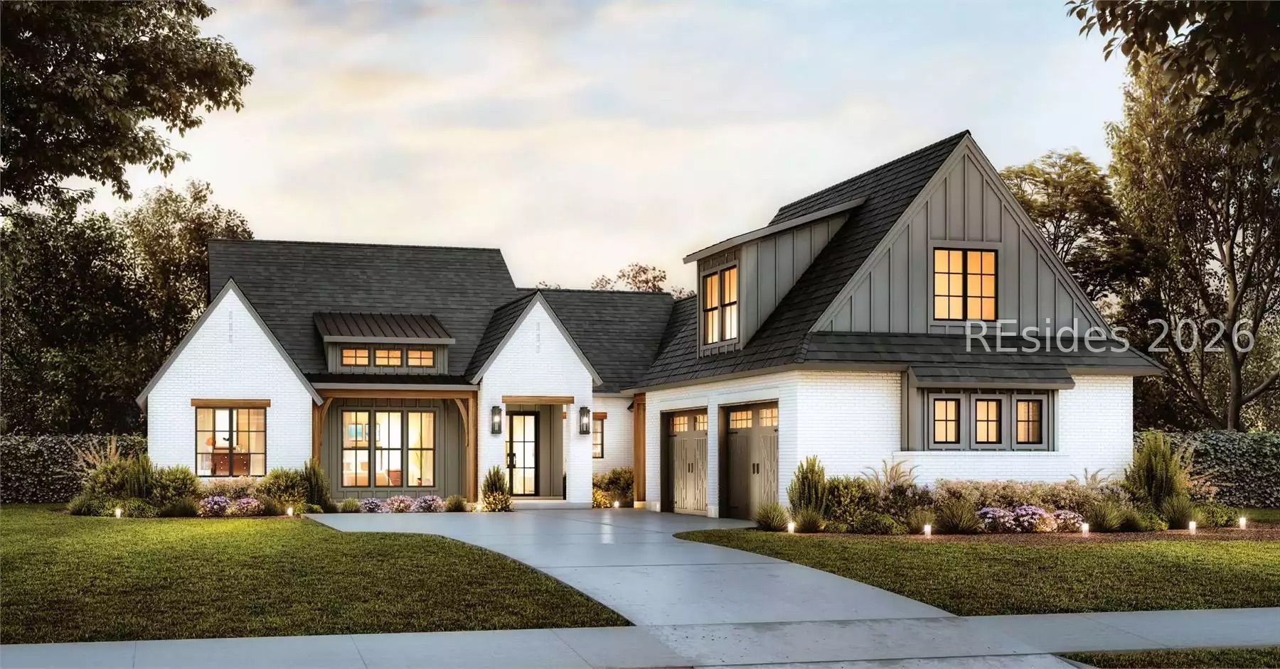 White brick home with dark gabled roofs, glowing windows, double garage, and landscaped front yard.