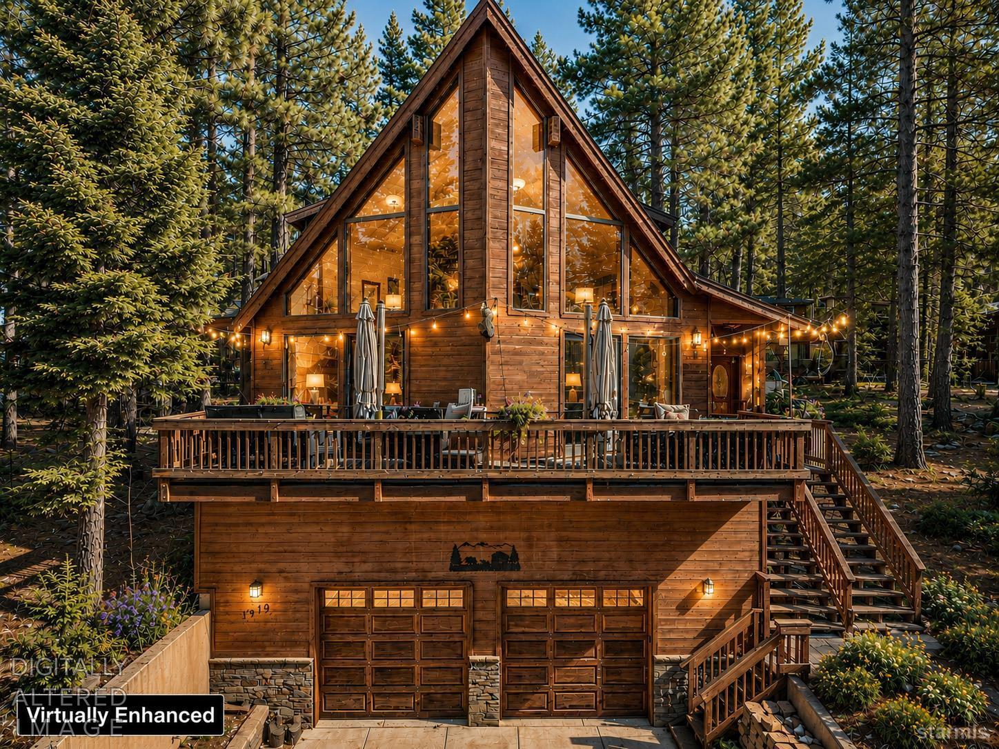 Wooden A-frame home glowing at dusk among pine trees, with a broad deck and string lights.