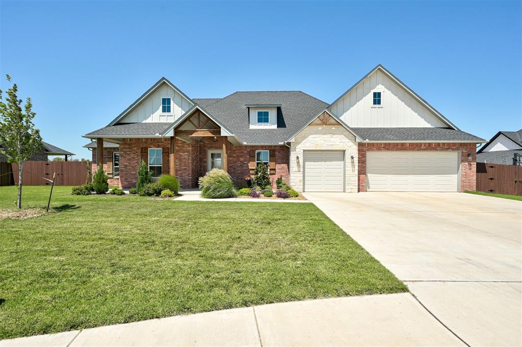 Brick-and-stone house with multiple gables, a two-car garage, and a broad front lawn.