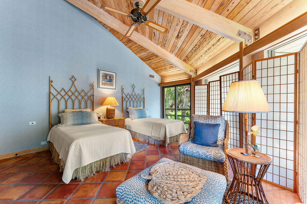 Bedroom with twin beds, a vaulted wood ceiling, terracotta tile, and shoji-style screens.