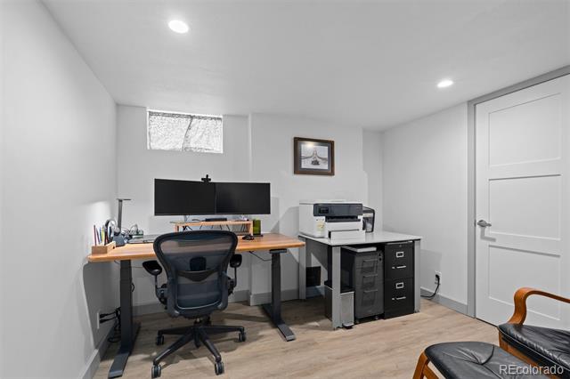 Home office with a standing desk, dual monitors, printer, and filing cabinets.