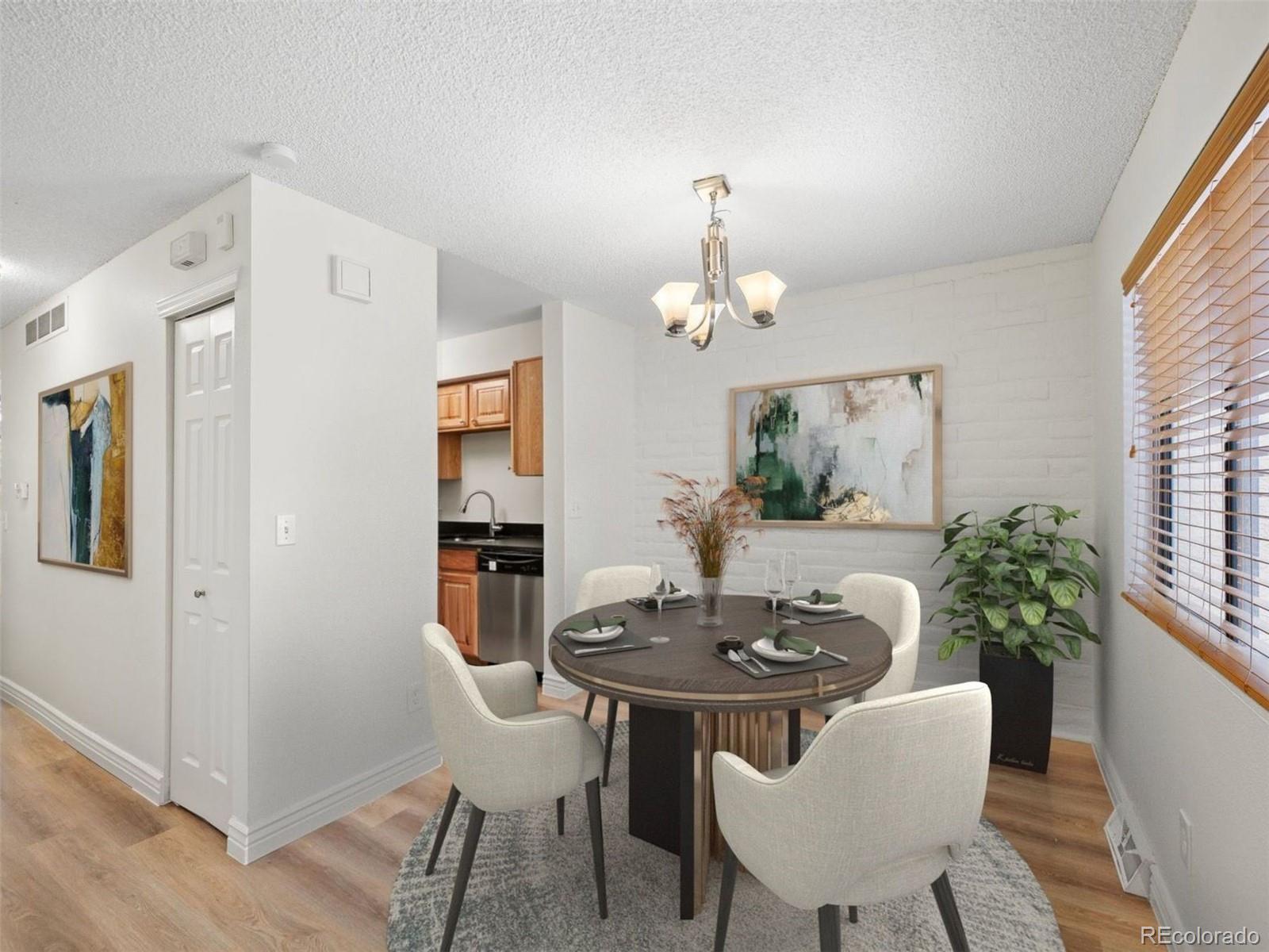 Condo dining area with a round table, upholstered chairs, and an open view into the kitchen.