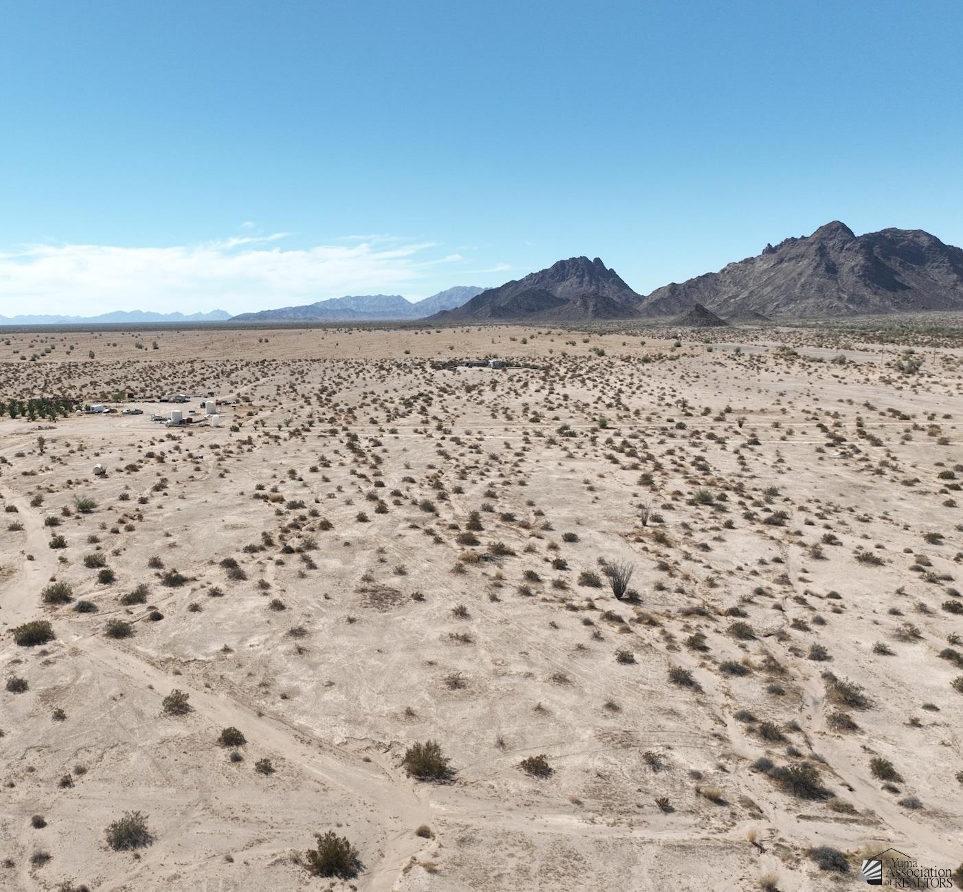 Aerial view of a scrub-covered desert parcel with rugged mountains on the horizon.