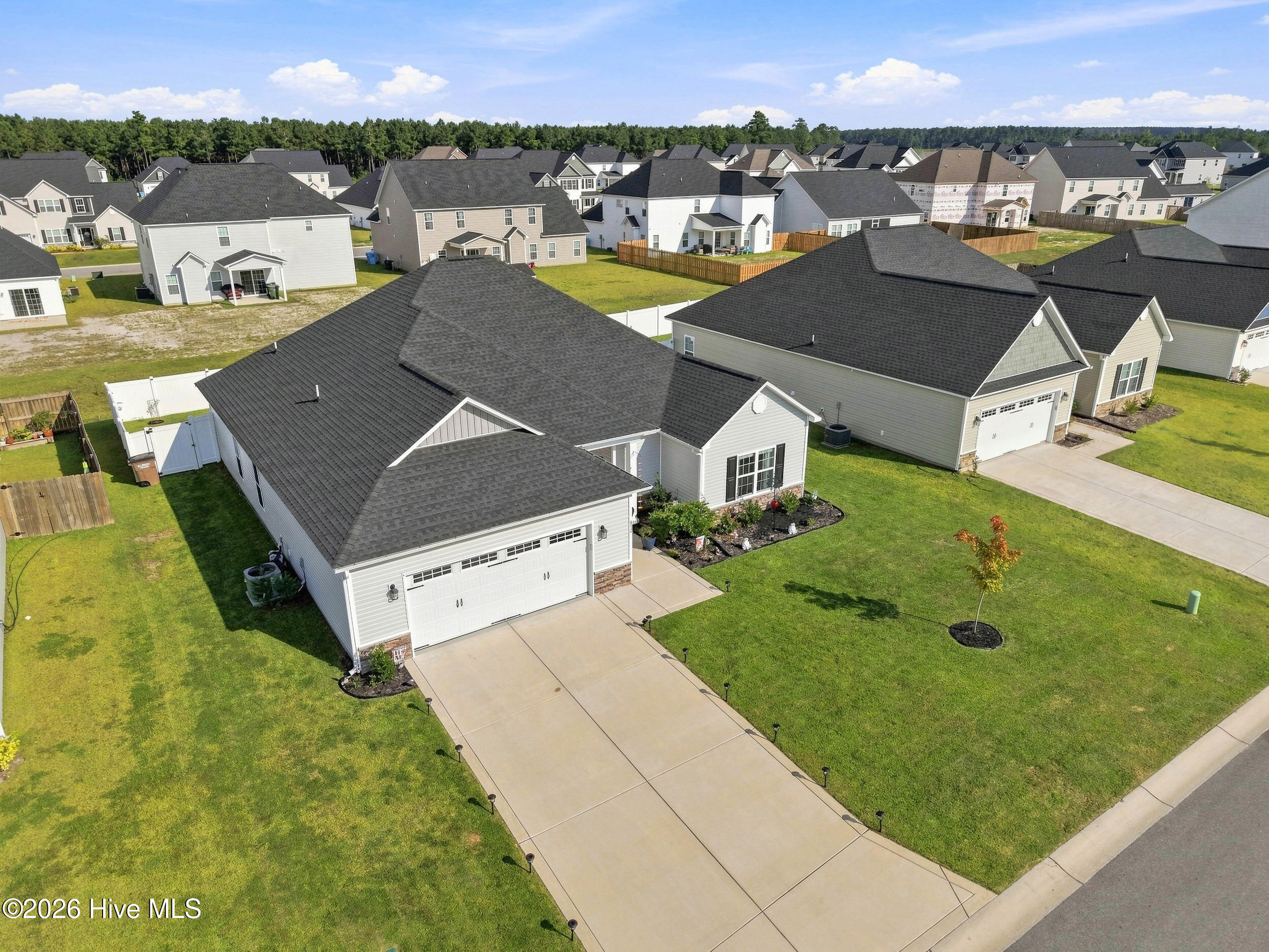 Aerial view of a gray single-story home with a two-car garage and wide driveway.
