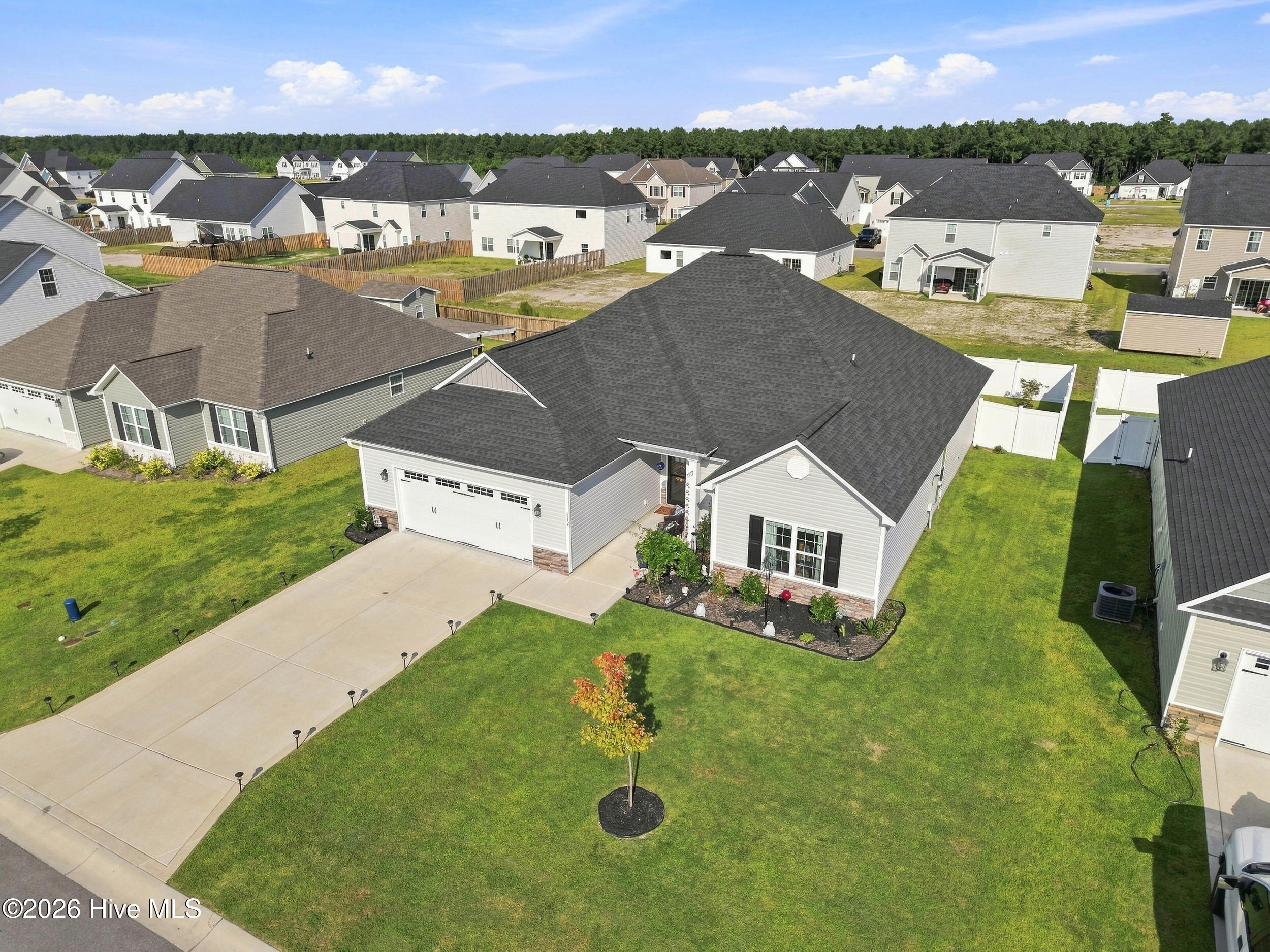 Aerial view of a single-story home with an attached two-car garage and broad driveway.