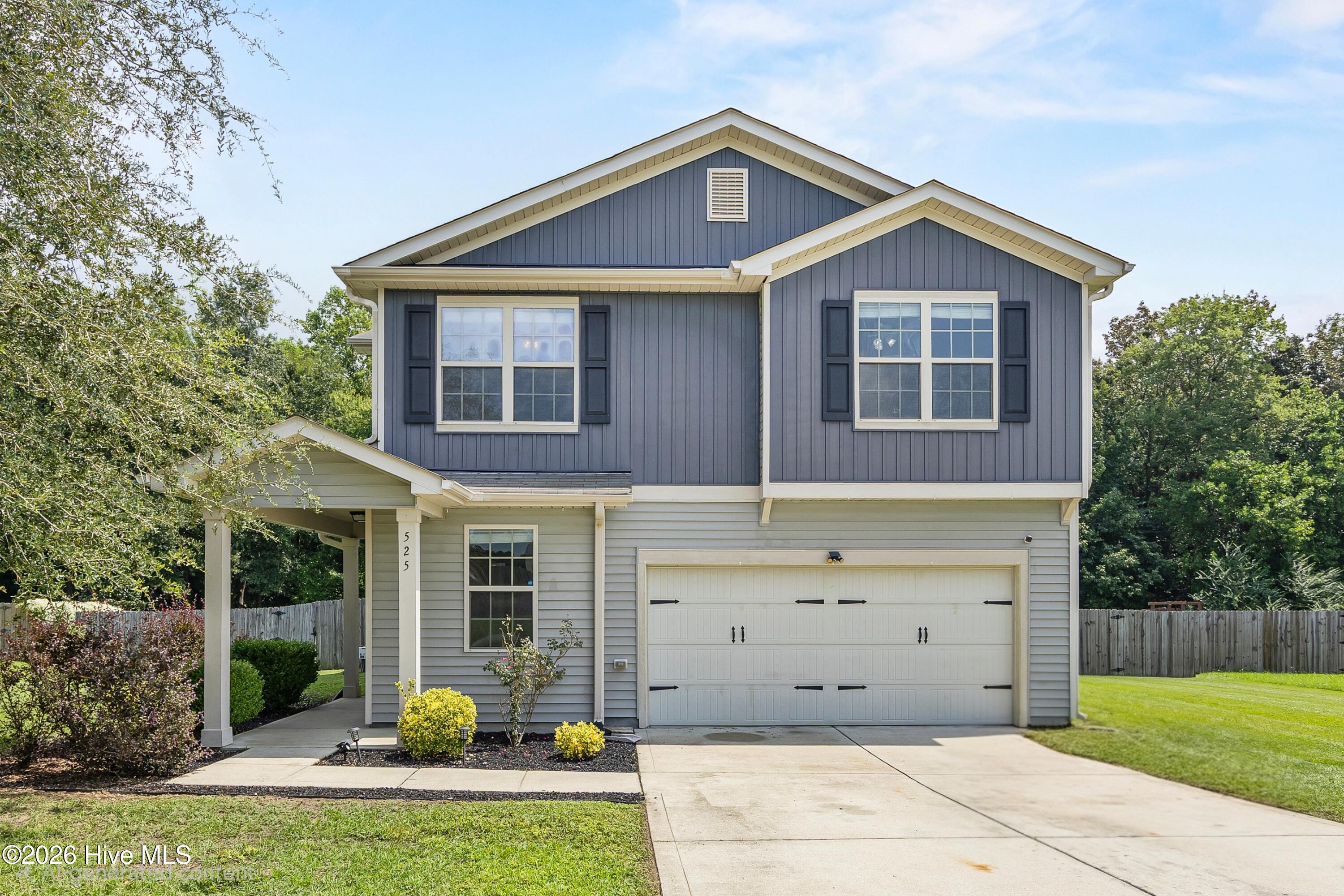 Two-story gray house with a covered entry, double garage, and wide driveway.