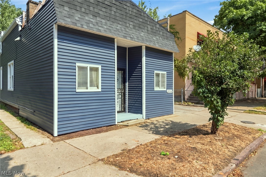 Blue-sided property with white trim and a steep gray roof on Bridge Avenue.