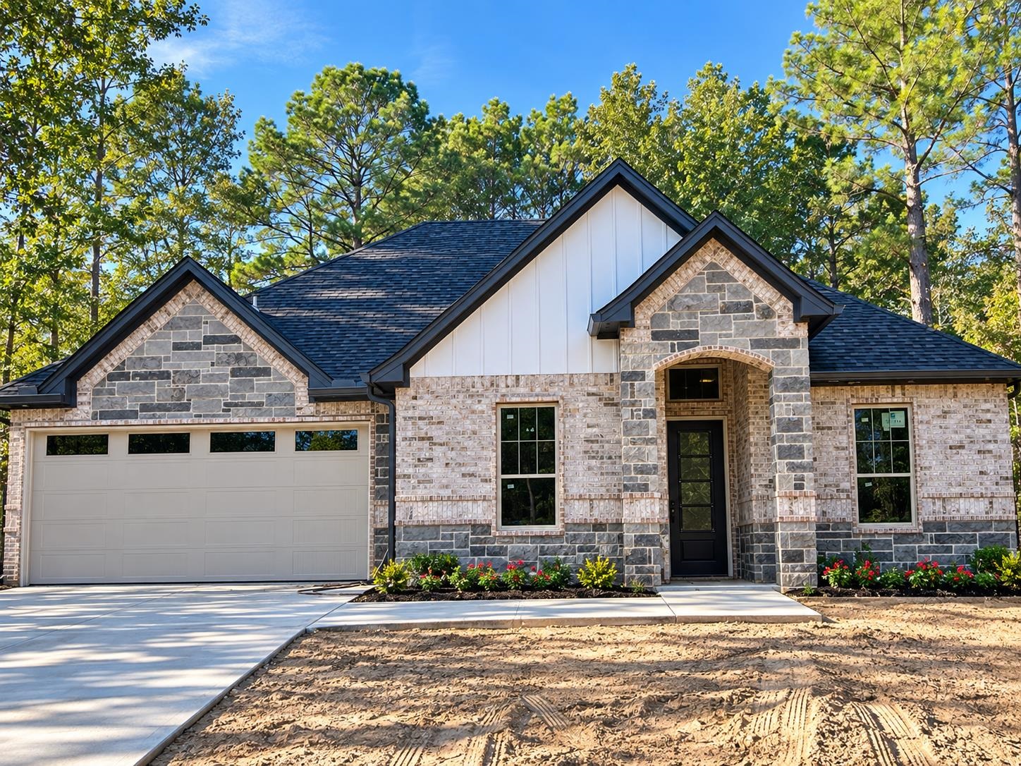 Stone-and-brick home with a double garage, covered entry, and unfinished front yard.