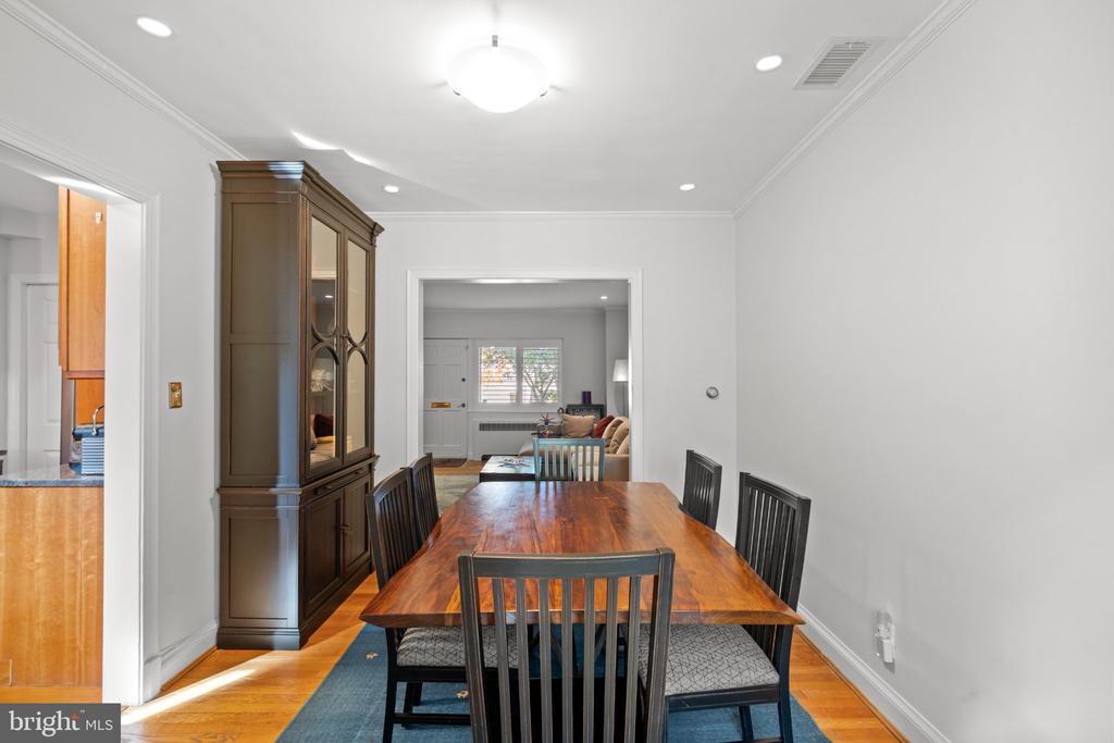 Dining room with a long wooden table, dark chairs, and a tall china cabinet.
