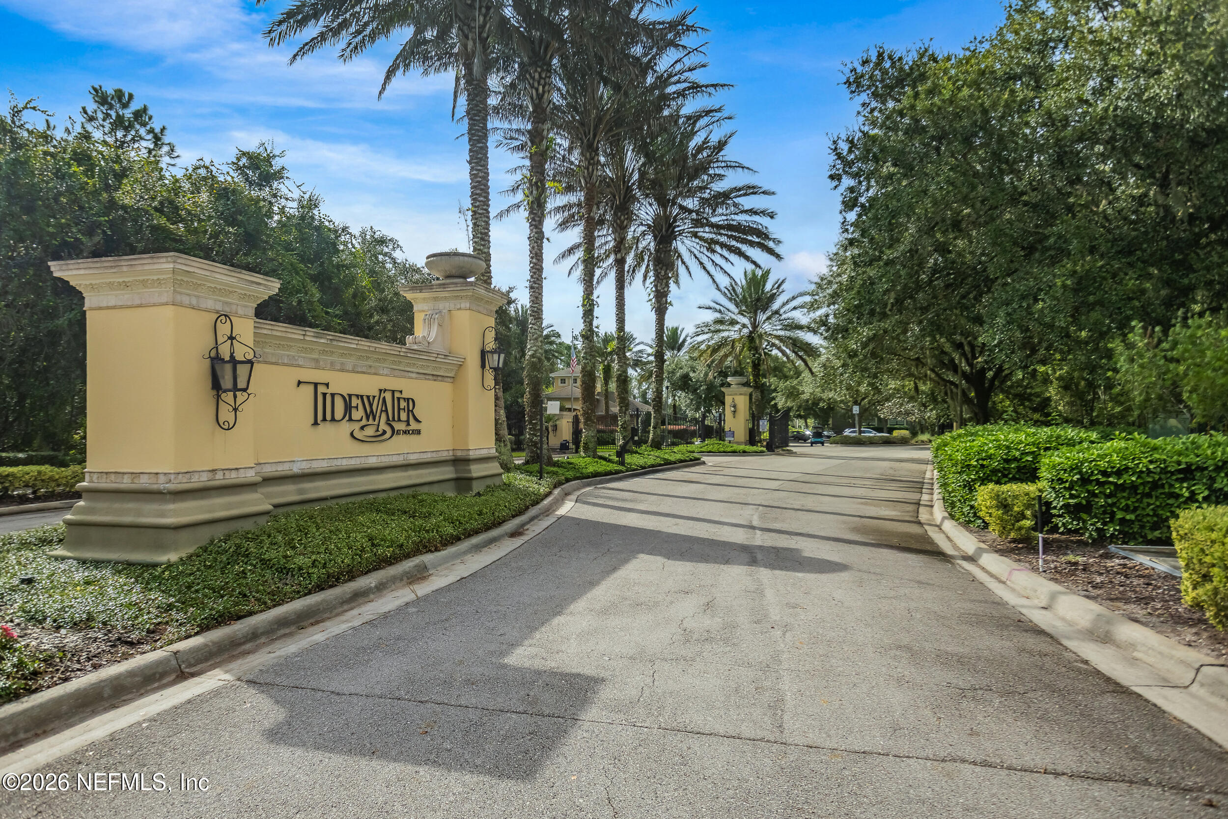 Tidewater at Nocatee entrance with a yellow monument sign and palm-lined drive.