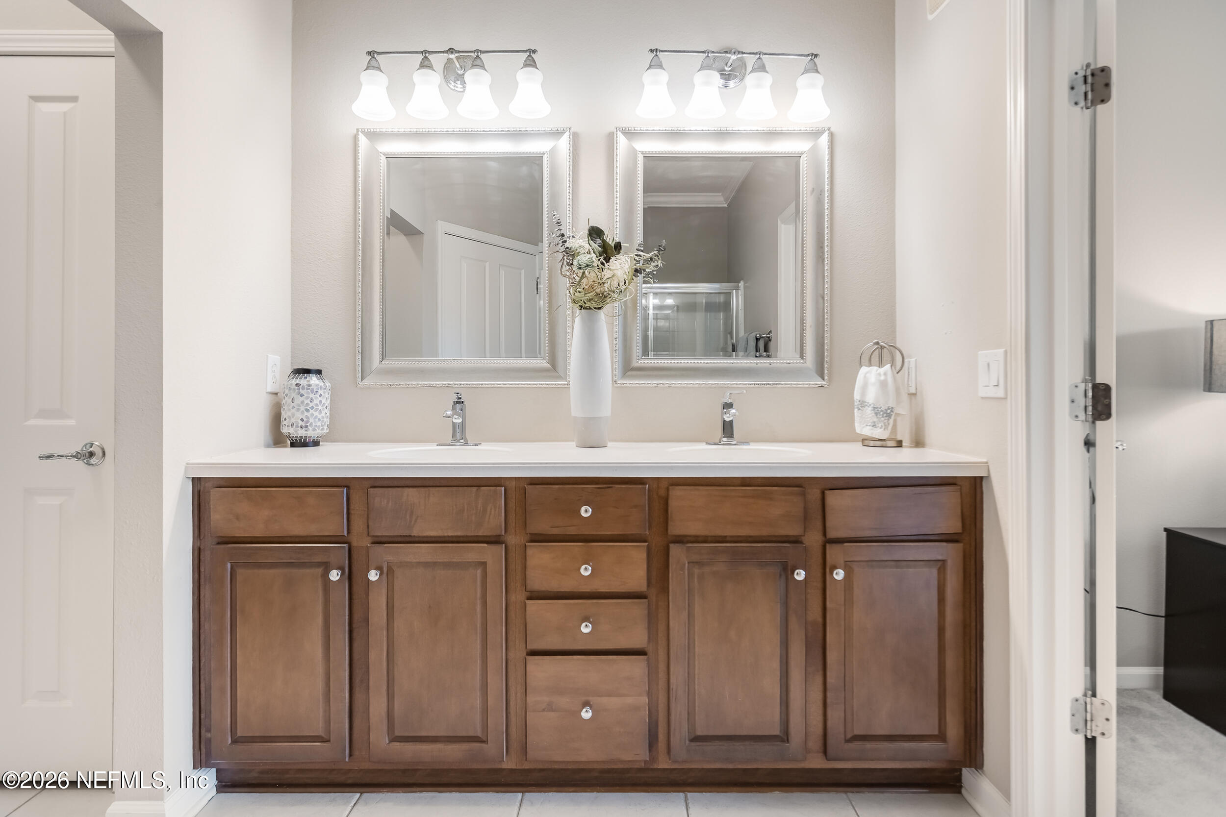 Bathroom with a dark wood double vanity, two sinks, and matching framed mirrors.