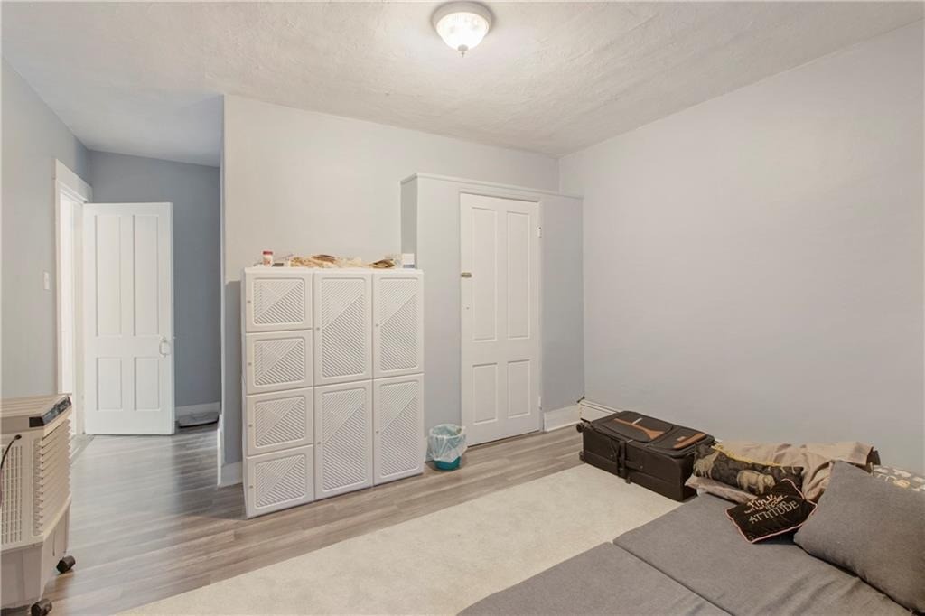 Living room with a gray sectional, pale rug, and white storage cabinet.