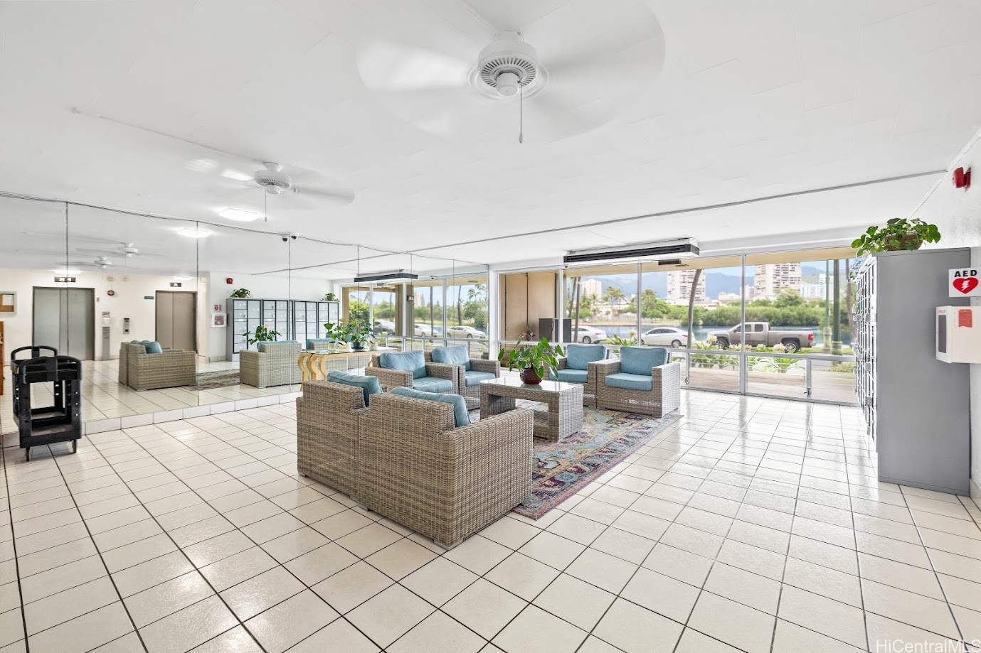 Building lobby lounge with wicker seating and broad windows overlooking the water.
