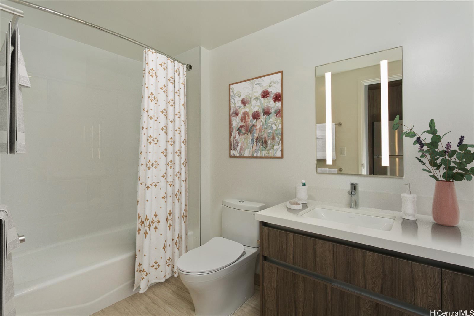 Bathroom with a glass-enclosed tub, patterned shower curtain, and dark wood vanity.