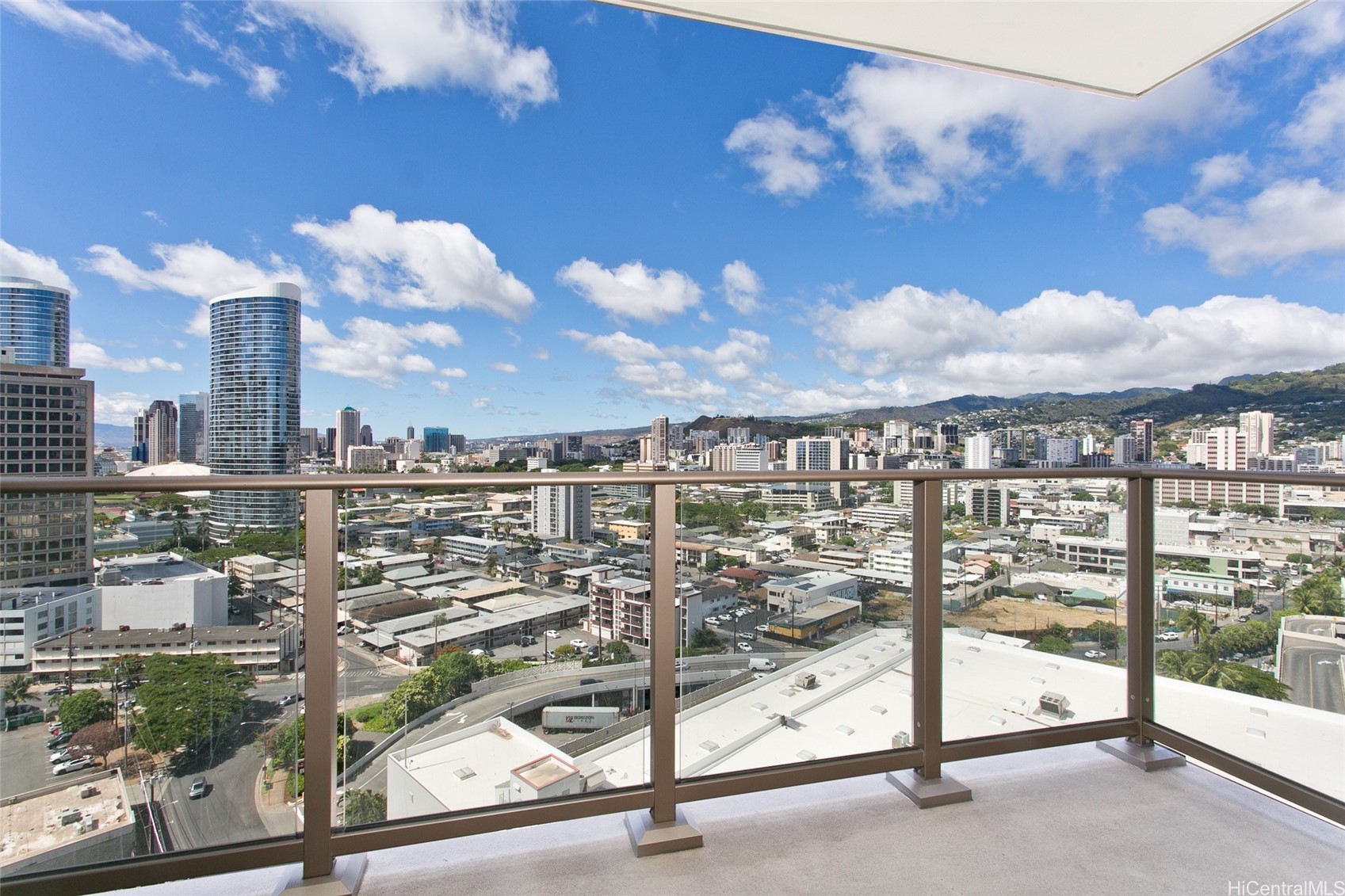 Balcony overlooking Honolulu's city skyline and green hills.