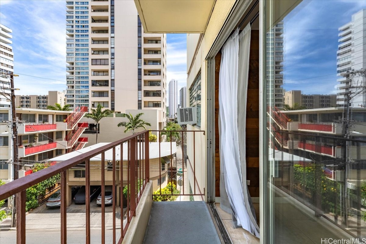 Apartment balcony overlooking nearby residential buildings and a courtyard.