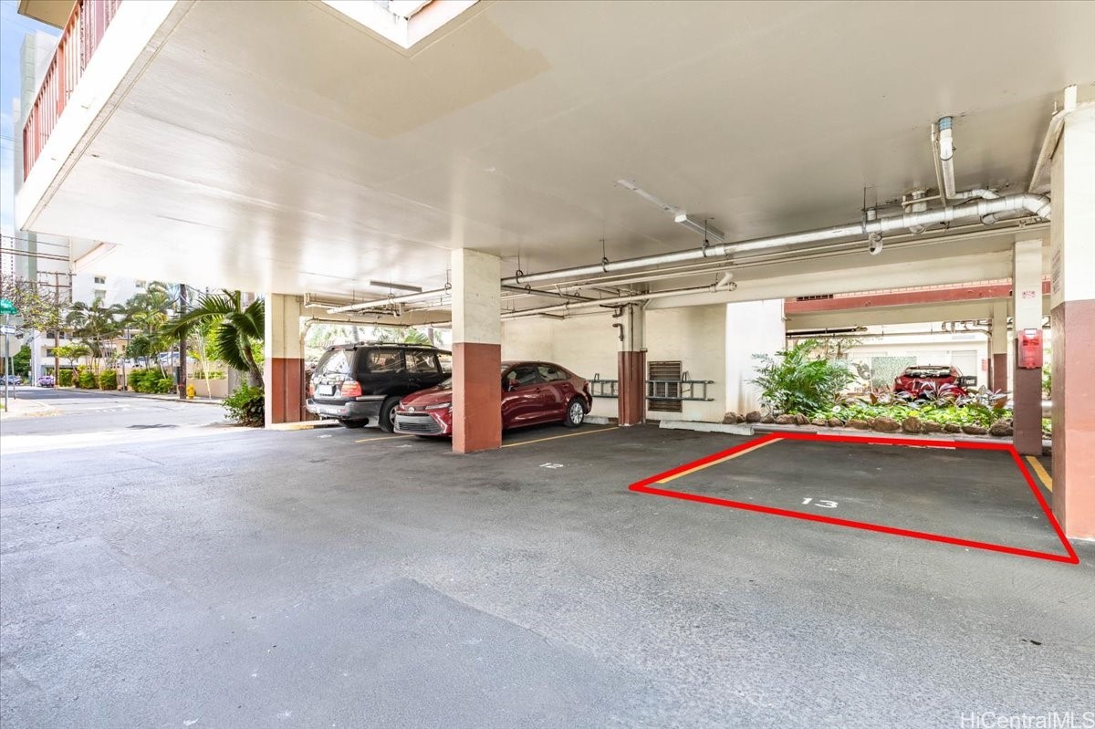 Covered parking area with stall 13 outlined in red beside two parked cars.