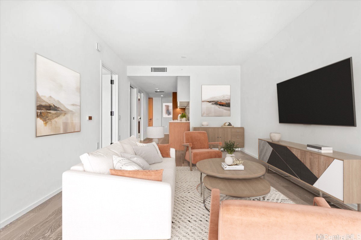 Living room with a white sofa, terracotta chairs, and a wall-mounted television.