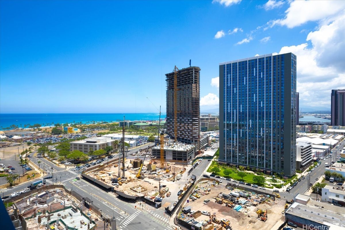 Aerial view of Honolulu construction sites, high-rises, and ocean.
