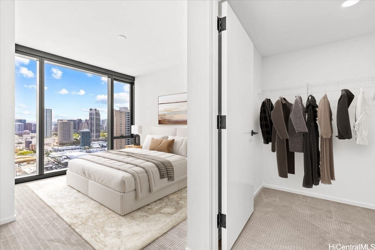 Bedroom with a king bed beside floor-to-ceiling windows overlooking the city, and an open walk-in closet.