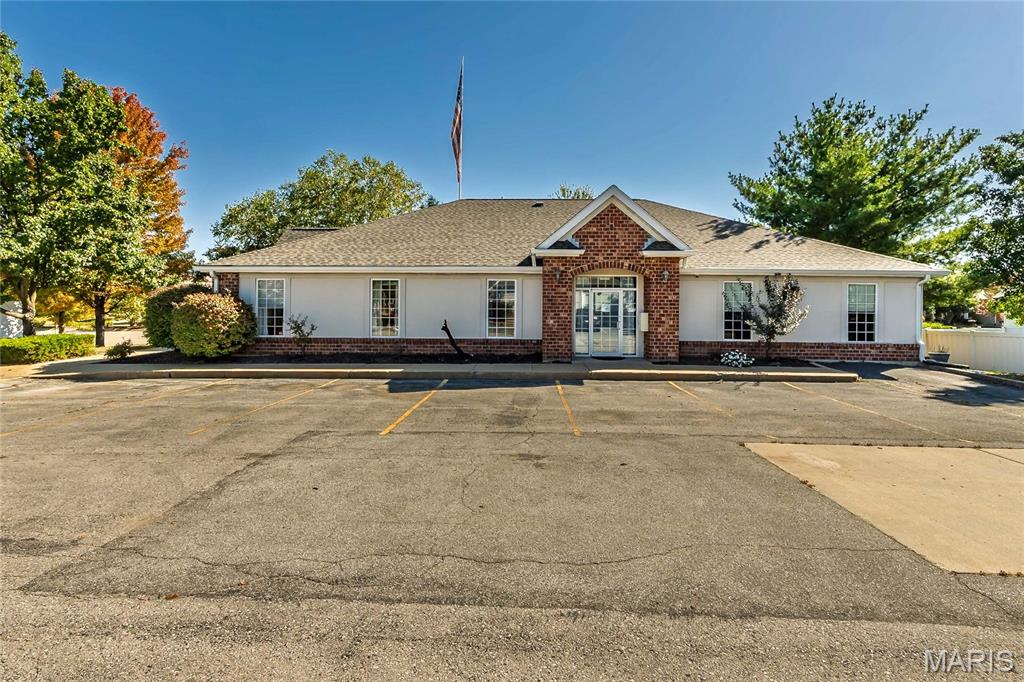 Single-story building with a brick entrance and paved parking lot.