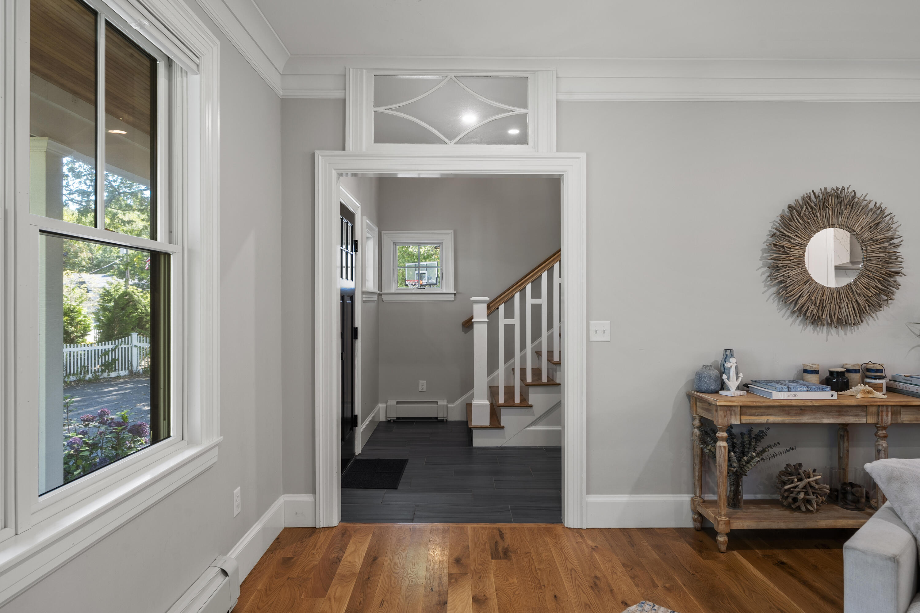 Sitting room looking through a wide doorway toward the entry hall and staircase.