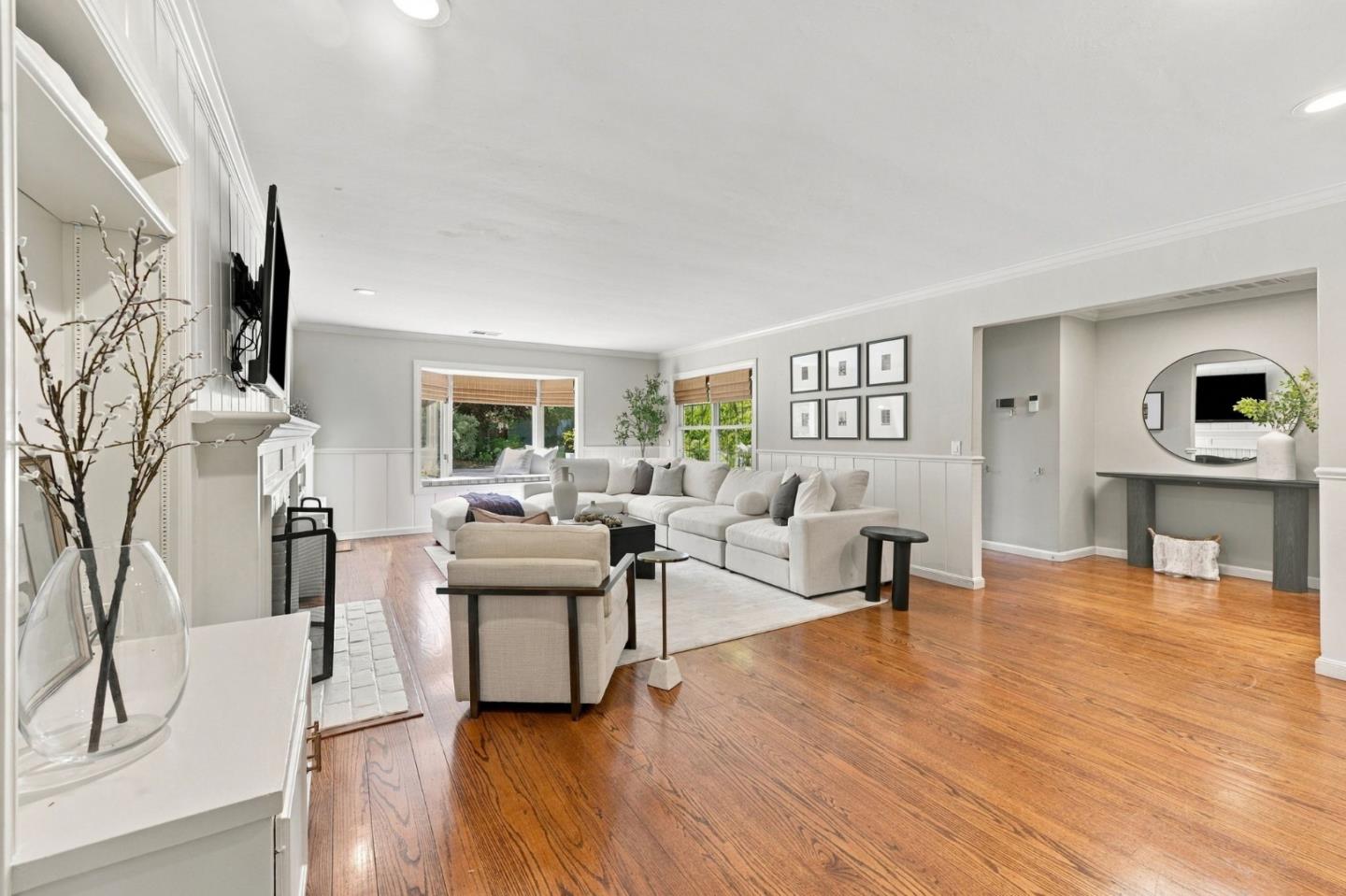 Staged living room with a white sectional, hardwood floors, and a fireplace.