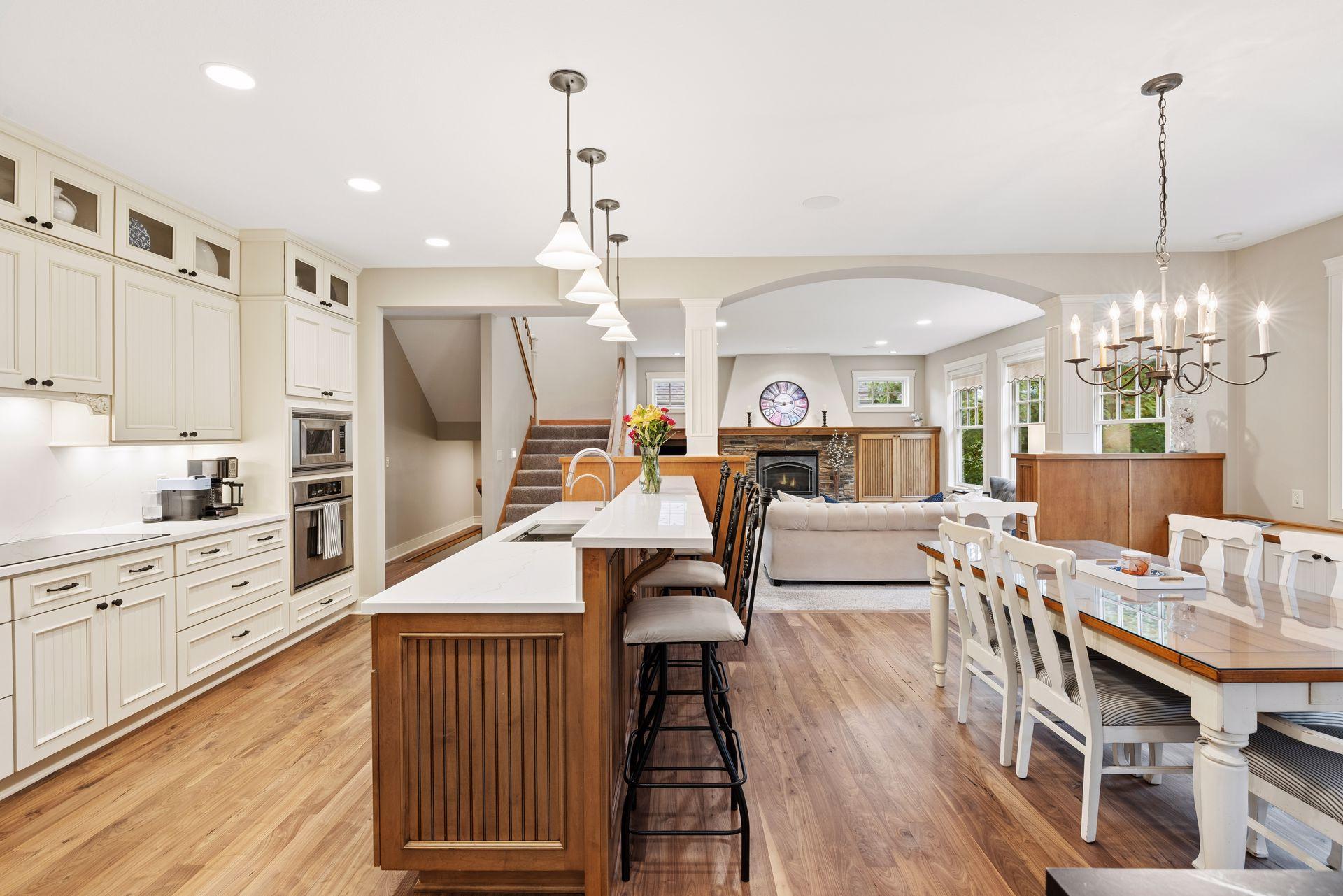 Open kitchen and living area with a large island, fireplace, and dining table.