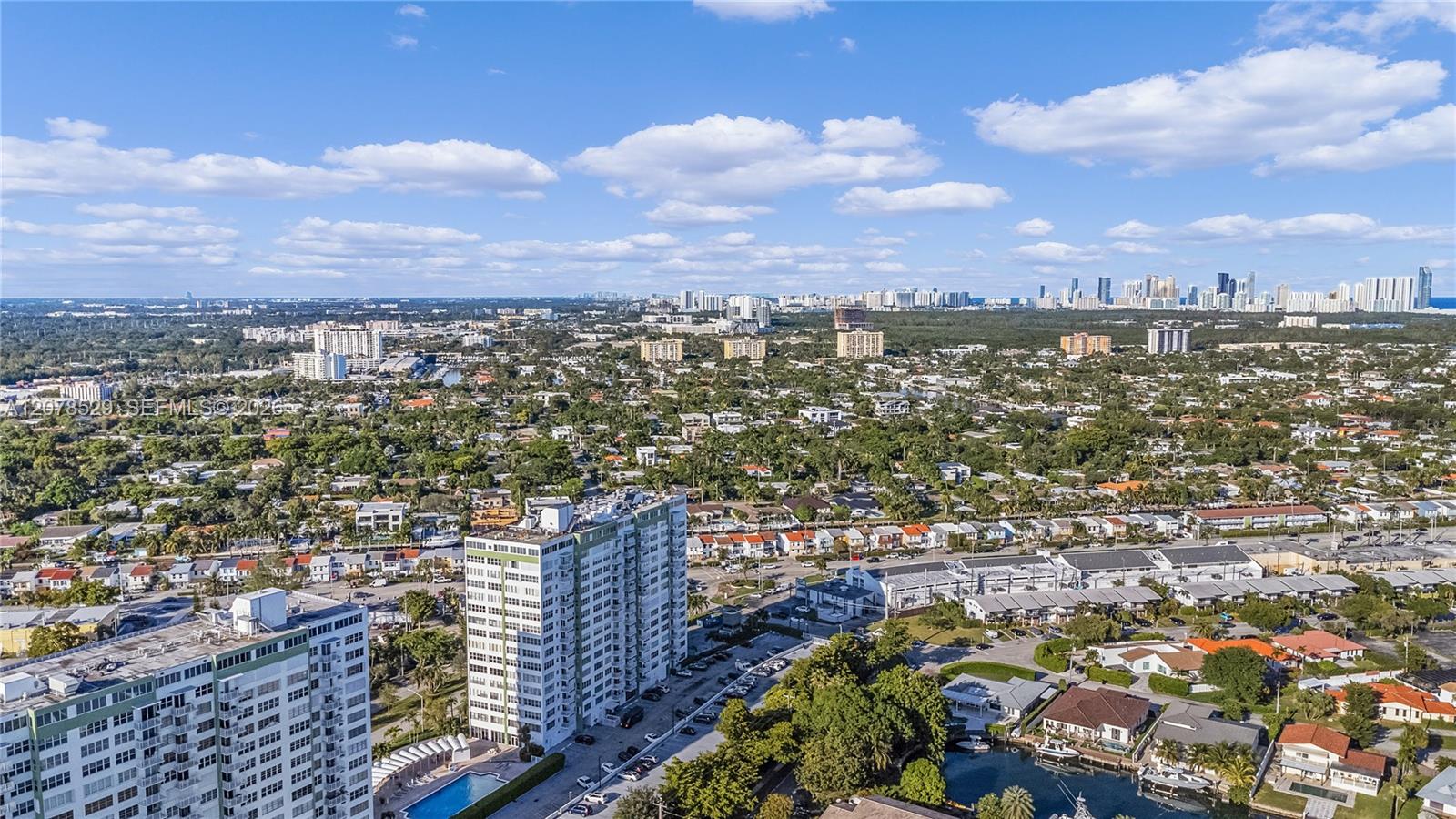 Aerial view of North Miami homes and condo towers, with the Miami skyline in the distance.