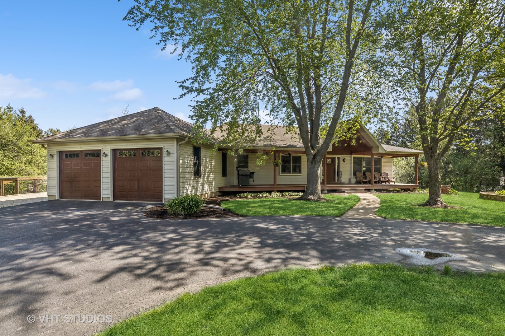 Single-story home with a two-car garage, shaded lawn, and covered front porch.