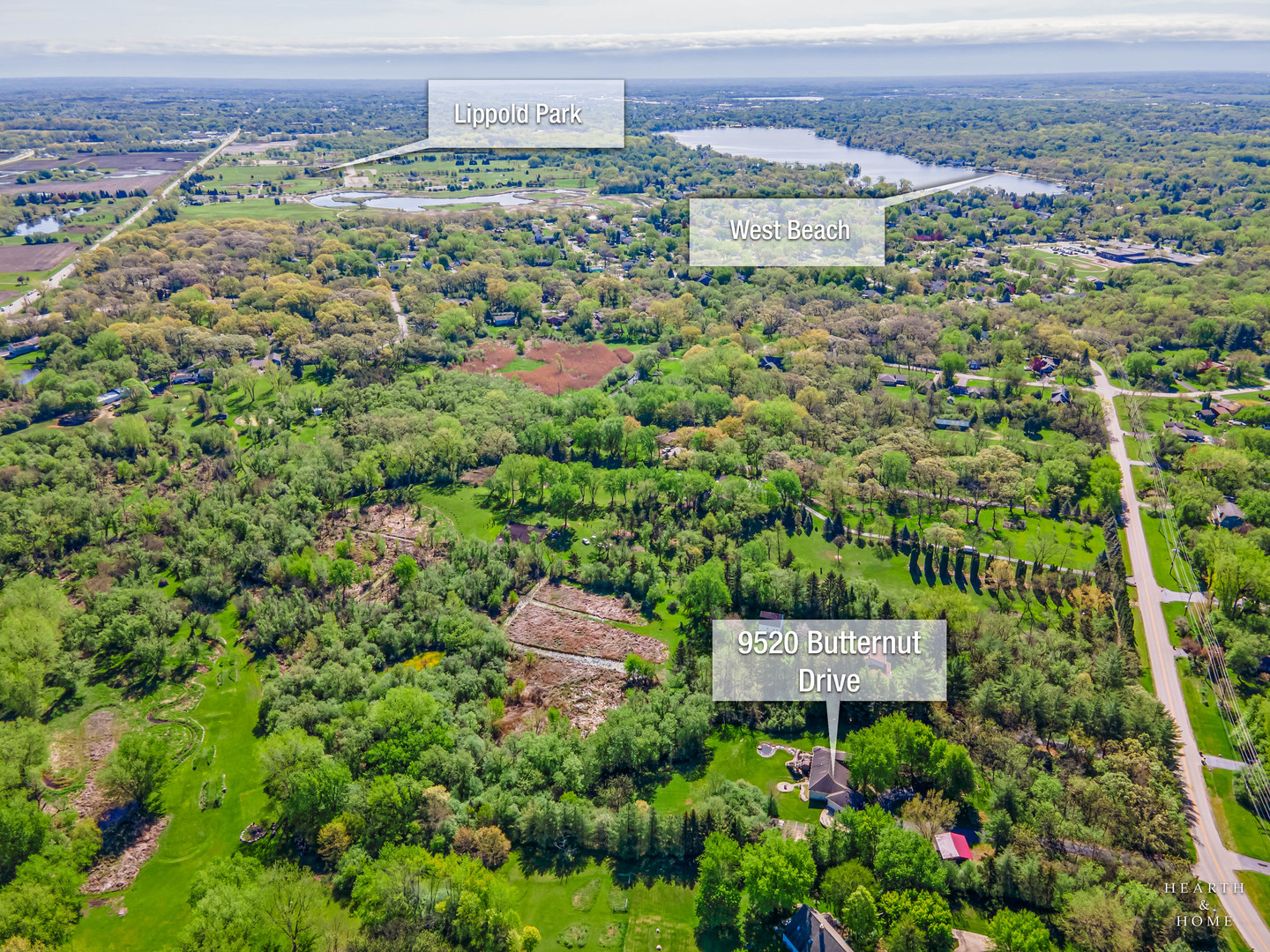 Aerial view of 9520 Butternut Drive amid wooded grounds, with West Beach and Lippold Park labeled nearby.
