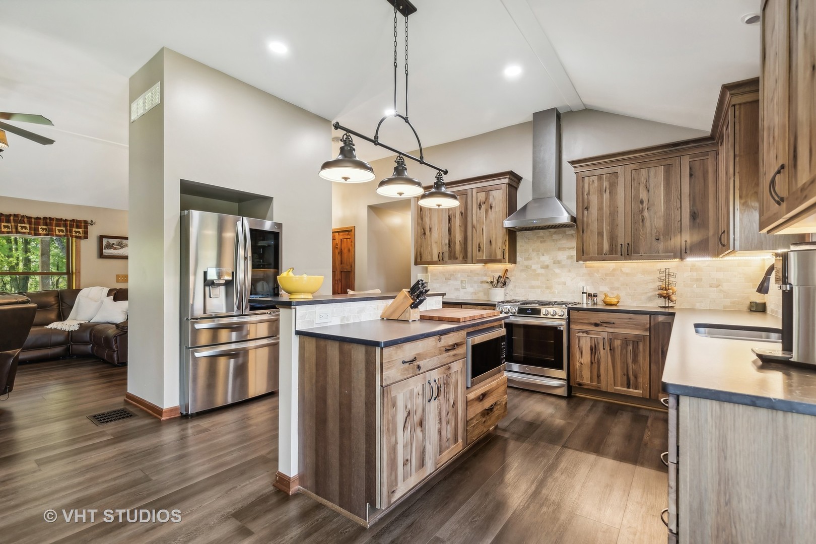 Kitchen with rustic wood cabinets, stainless steel appliances, and a large central island.