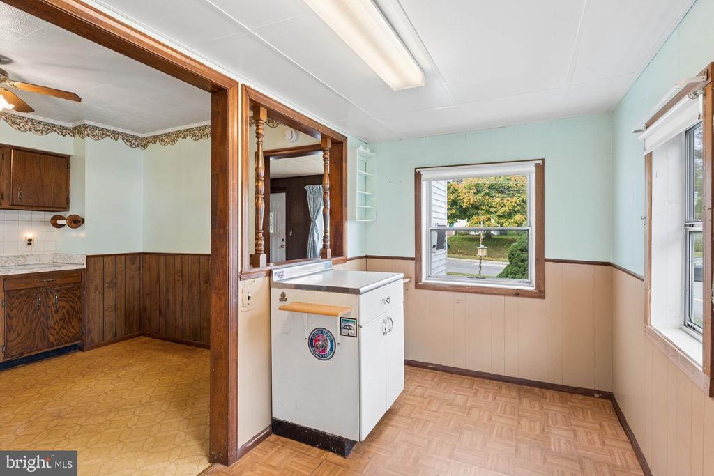 Kitchen with dark wood cabinetry, decorative wood trim, and patterned flooring.