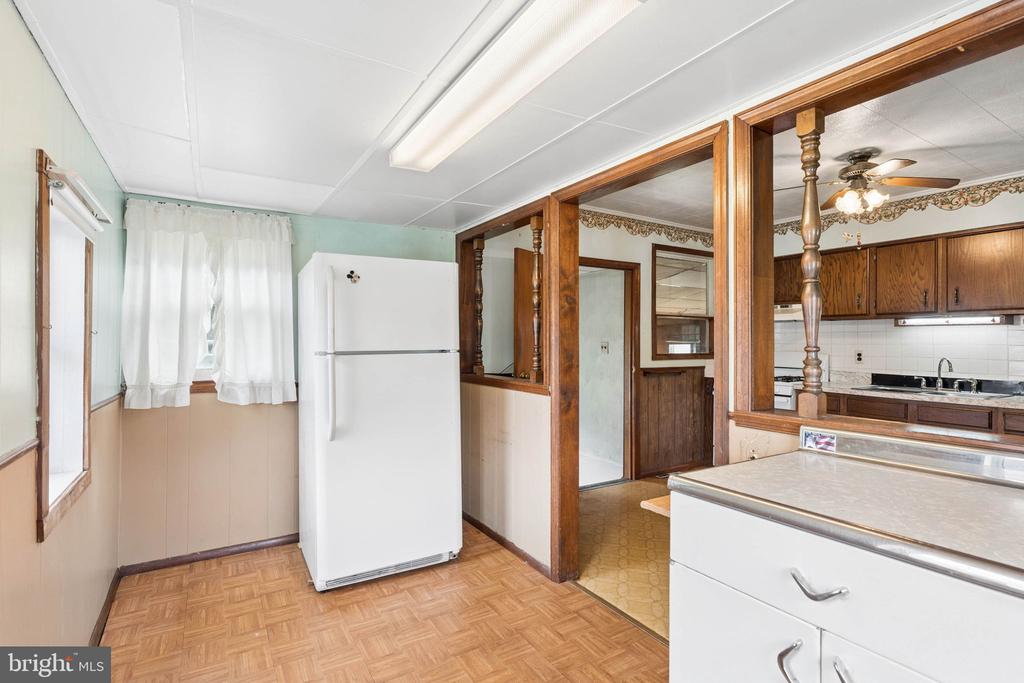 Kitchen with a white refrigerator, wood cabinetry, and a pass-through counter.