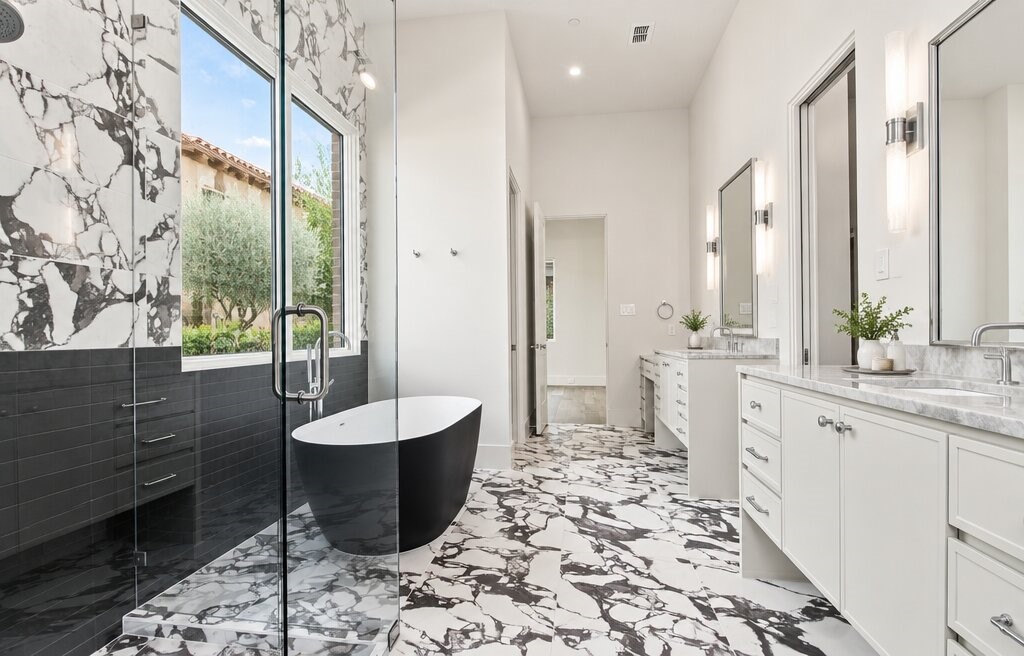 Bathroom with a freestanding black soaking tub, glass shower, and black-and-white marble flooring.