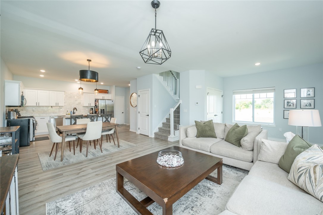 Open-plan living room with a large sectional sofa, dining area, and staircase.