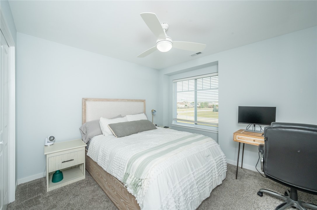 Bedroom with white bedding, a window with blinds, and a desk with a television.