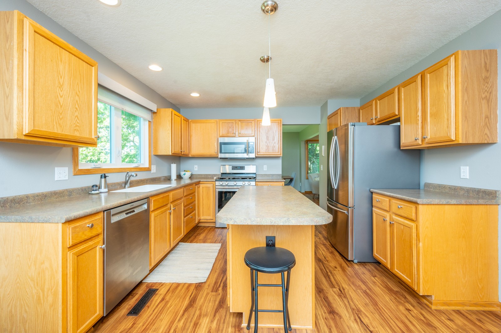 Kitchen with honey-colored cabinets, a central island, and stainless steel appliances.