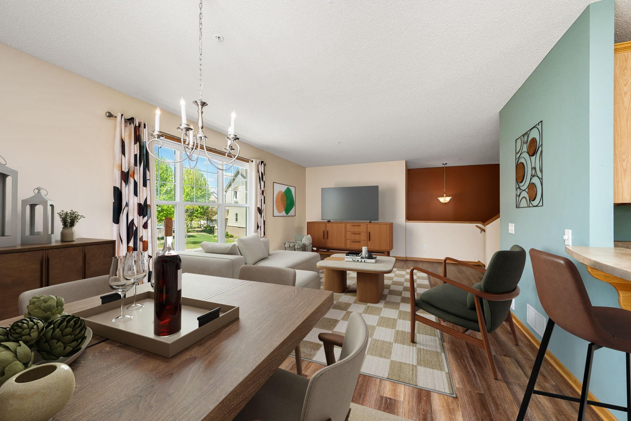 Open-plan living and dining room with large windows, wood floors, and a turquoise accent wall.