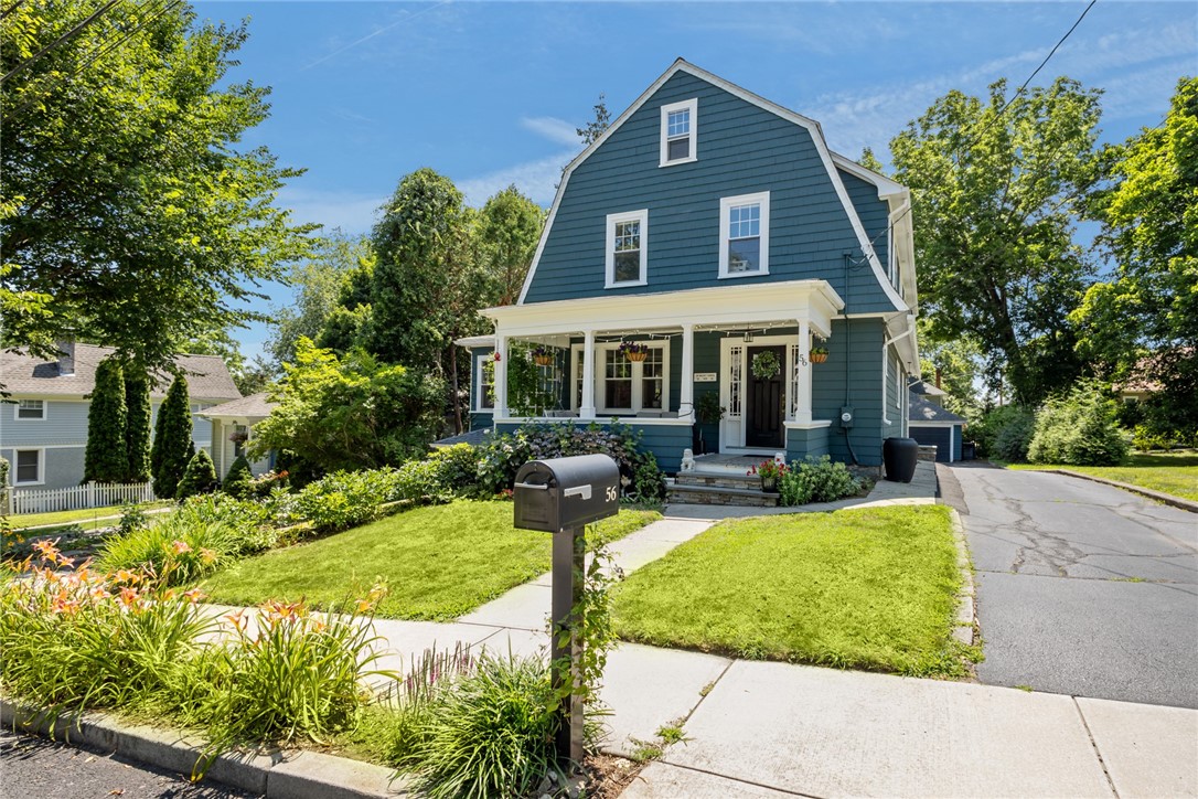 Blue two-story house with a white-trimmed covered porch and mailbox marked 56.
