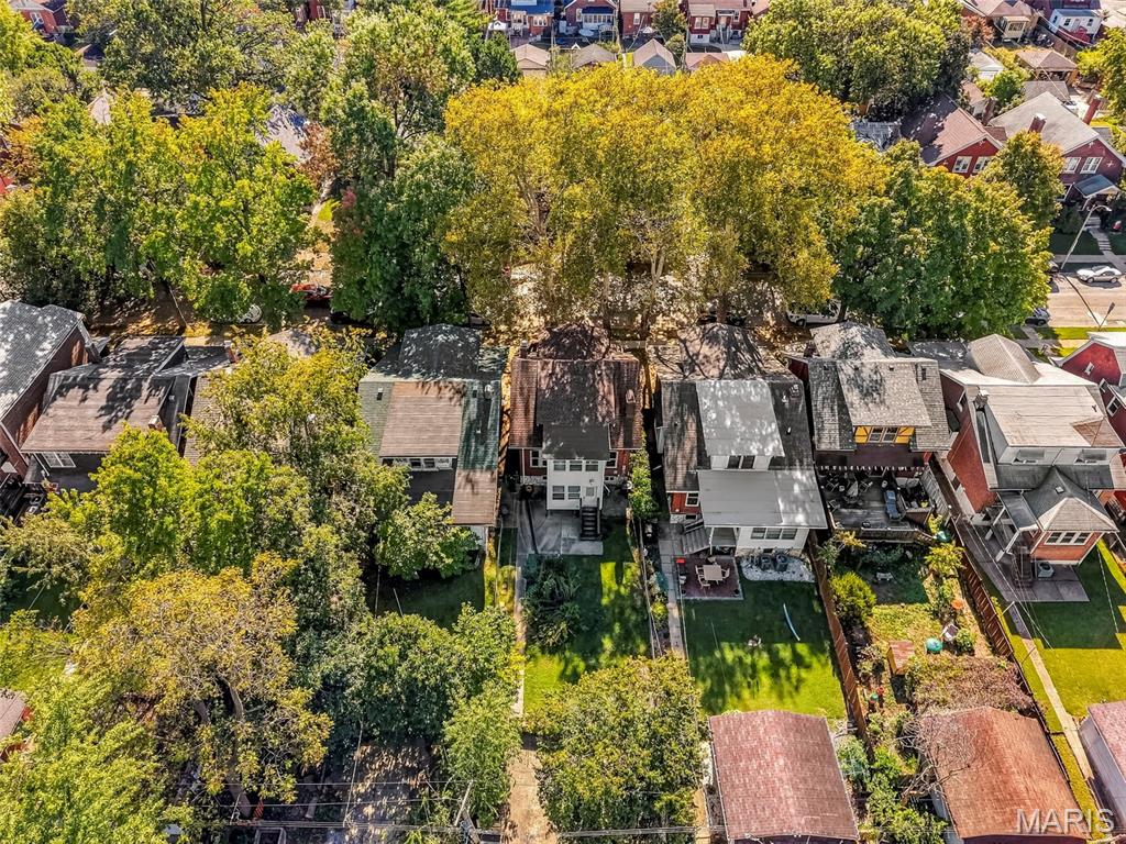 Aerial view of 931 Dover Place, with its backyard and mature autumn trees.